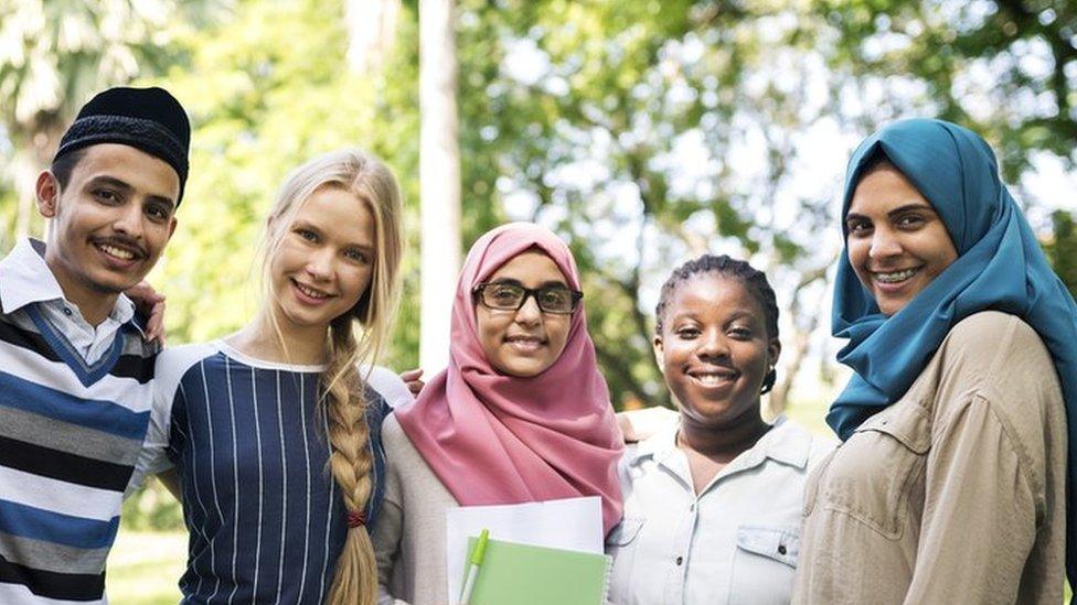 Teenagers from diverse backgrounds stand together