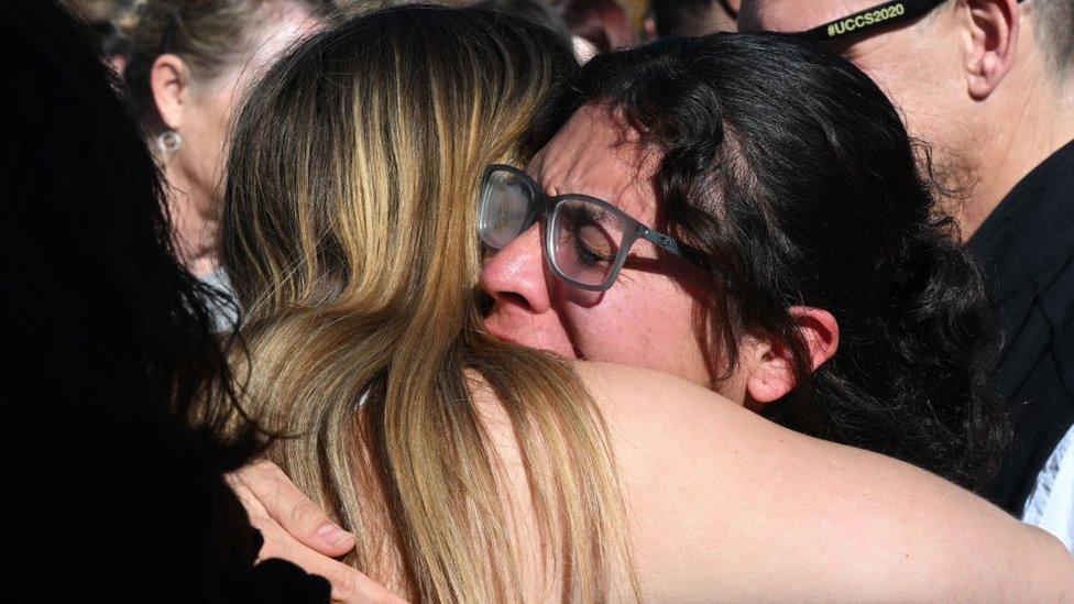 Friends of the victims of a Colorado university shooting cry at vigil