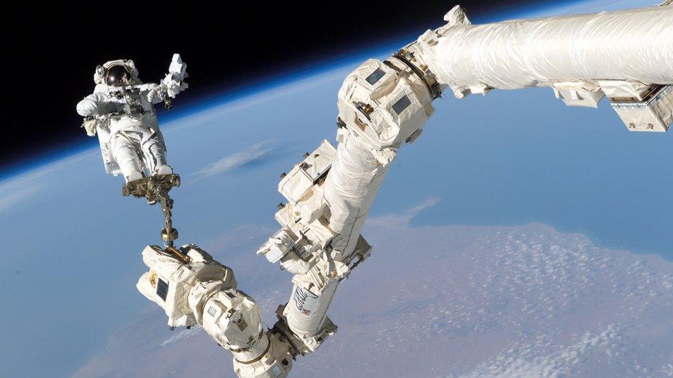 Astronaut Stephen K. Robinso is anchored to a foot restraint on the International Space Stations Canadarm2