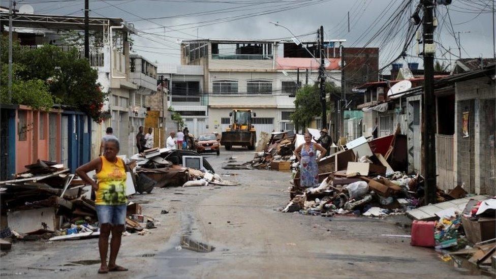 People stand among the rubble of houses damaged by heavy rains, in the Coqueiral neighbourhood, in Recife, Brazil, May 31, 2022