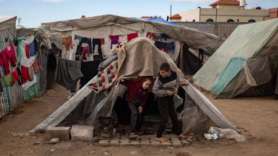 Palestinian children next to their tent inside the Rafah camp