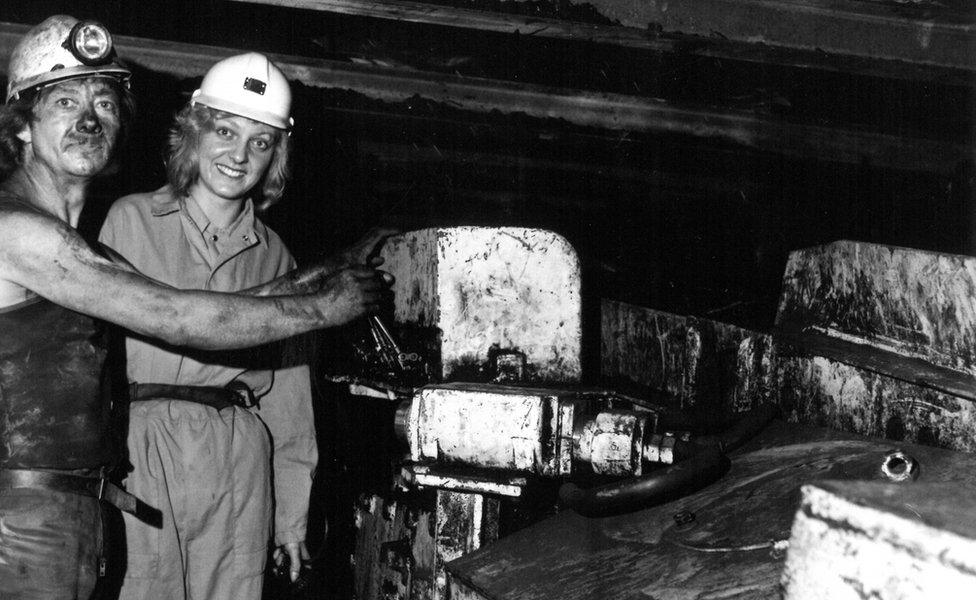 A man and a woman in a coal mine posing