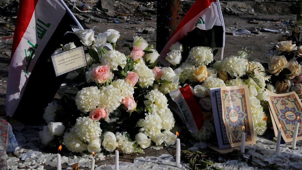 Iraqi flags, flowers and candles left at the scene of suicide bombing in Baghdad's Karrada district (6 July 2016)