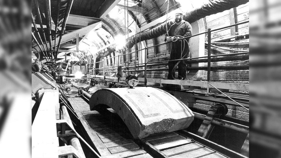 Construction worker in the channel tunnel and a conveyor belt in the 1970s