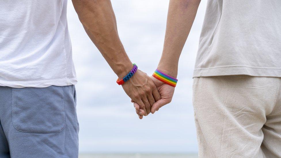 Two men holding hands