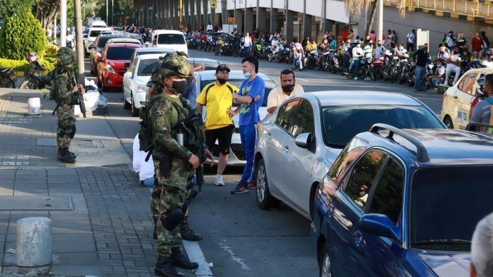 Cars and motorcycles queue up at a gas station, as Colombia faces a disruption in supplies of gasoline due to longevity of protests, in Cali, Colombia May 7, 2021