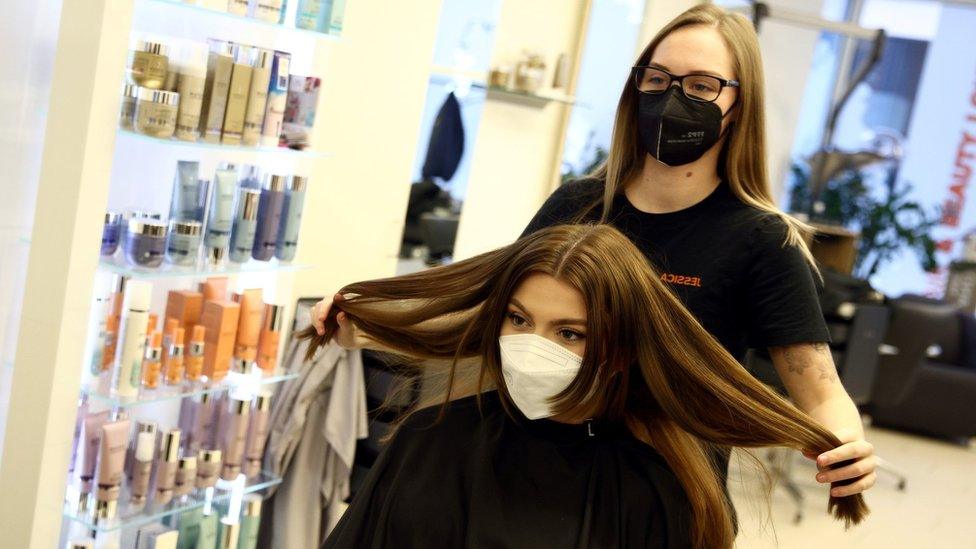 Hairdresser Jessica finishes the haircut of a customer