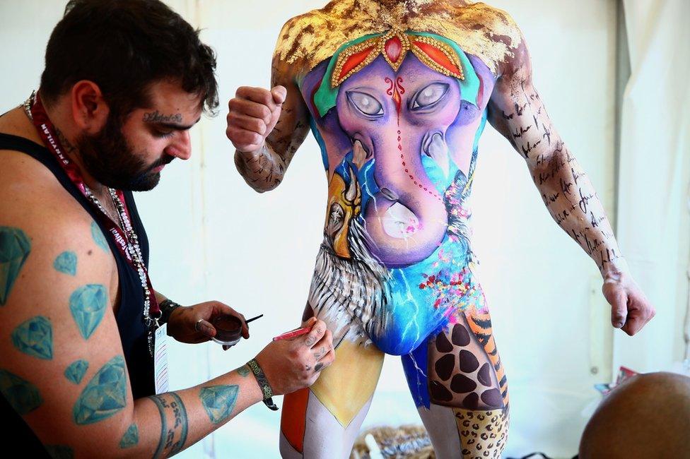 Make-up artist Jonathan Pavan from Brazil works on model Thiago during the World Bodypainting Festival 2018