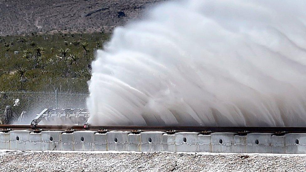 Sand is displaced as a test sled is slowed during the first test of the propulsion system at the Hyperloop One Test and Safety site