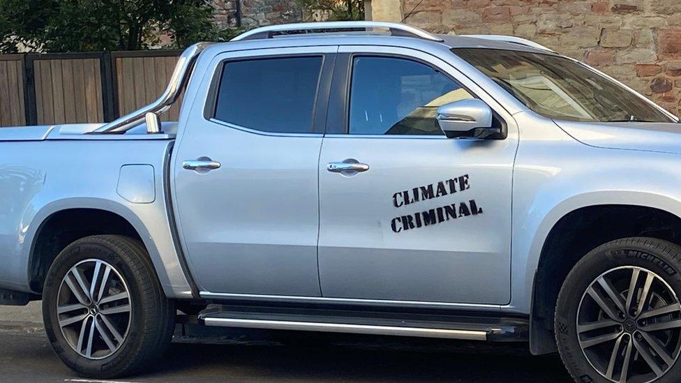 Car with 'climate criminal' written on the side