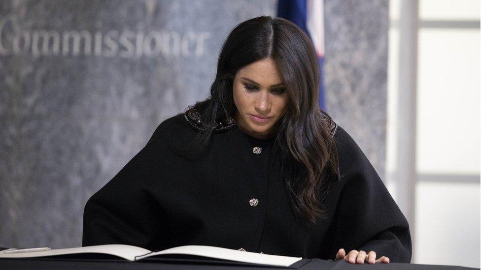 The Duchess of Sussex signs a book of condolence