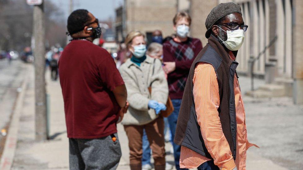 Residents wait in long line to vote in a presidential primary election outside the Riverside High School in Milwaukee, Wisconsin, on 7 April, 2020