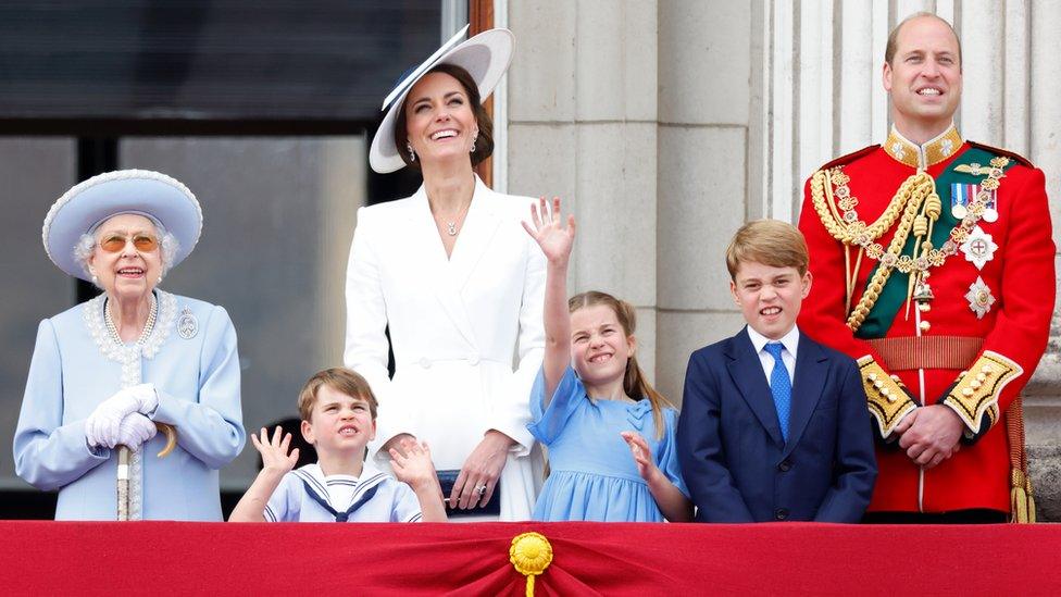 the royal family smile while watching the celebrations around them