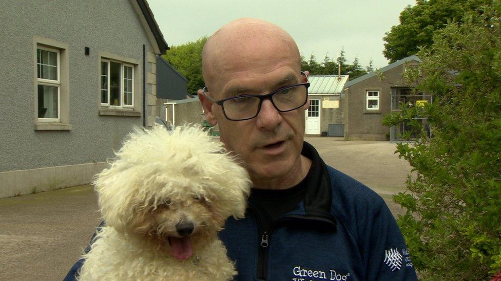 Nigel Devine holds Issy the dog