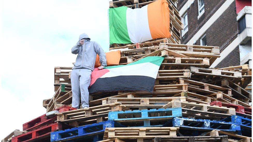 Youths rebuild bonfire close to New Lodge flats in north Belfast, Tuesday 8 August 2017