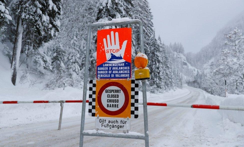 A sign warning of avalanche danger is seen on a closed road after heavy snowfall near Obertauern, Austria