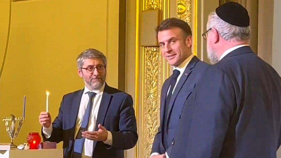 President Emmanuel Macron looked on as France's Chief Rabbi Haïm Korsia lit a candle for the first night of Hanukkah