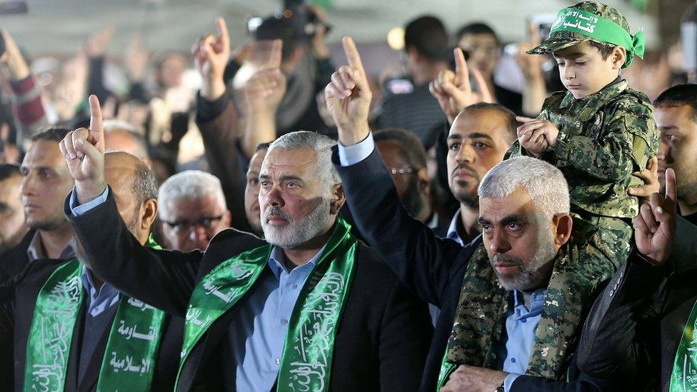 The new leader of Hamas movement in the Gaza Strip, Yahya Sinwar (R), holds on his shoulders the son of Mazen Fuqaha at a memorial (27 March 2017)