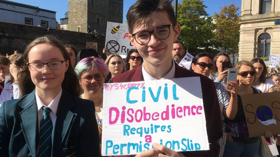 Two schoolchildren hold a placard at the climate change demonstration in Londonderry