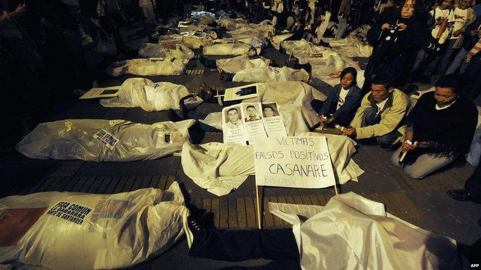 People demonstrate by covering themselves with sheets pretending they are false positive victims during a protest on 6 March, 2009, in Bogota.