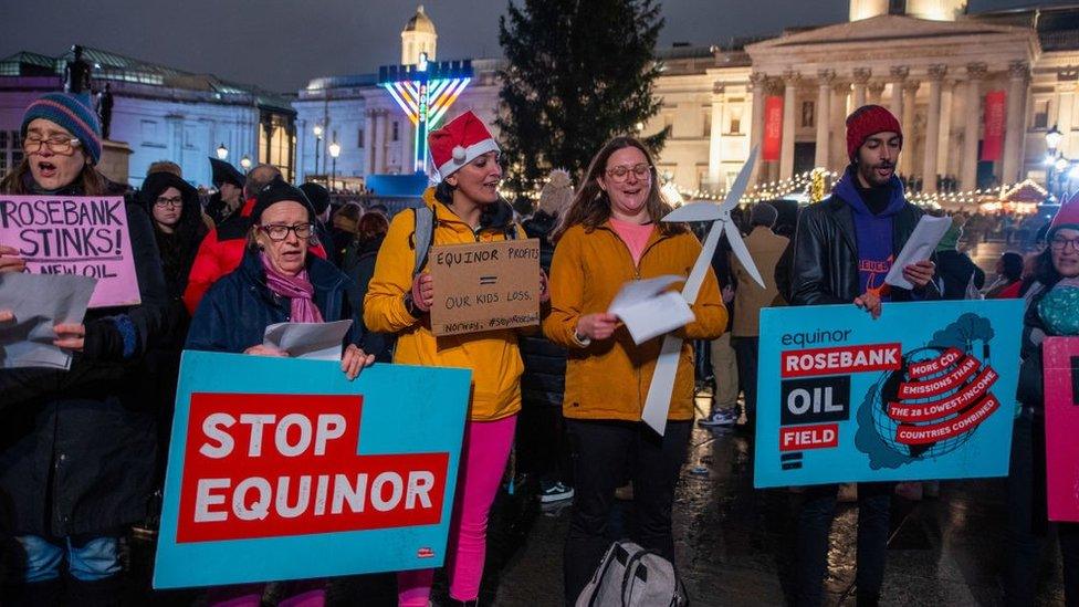 Protestors in Trafalgar square with placards criticising Equinor