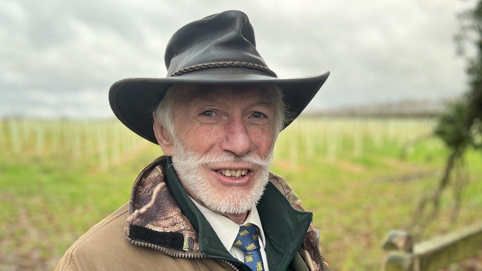 Richard Burden - Cranborne Chase National Landscape, Principle Landscape and Planning Officer leaning against a fence on the edge of the plantation