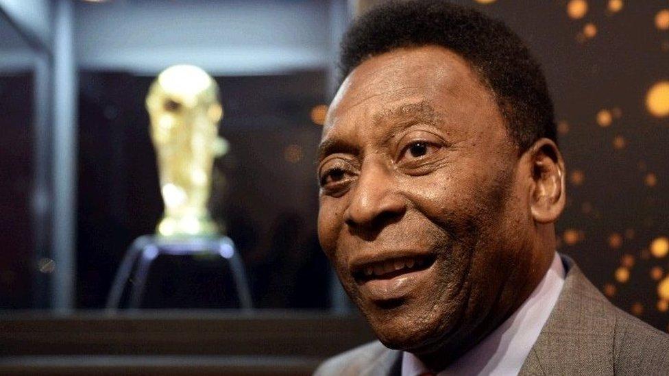 Pele pictured with the World Cup trophy behind him in a display cabinet