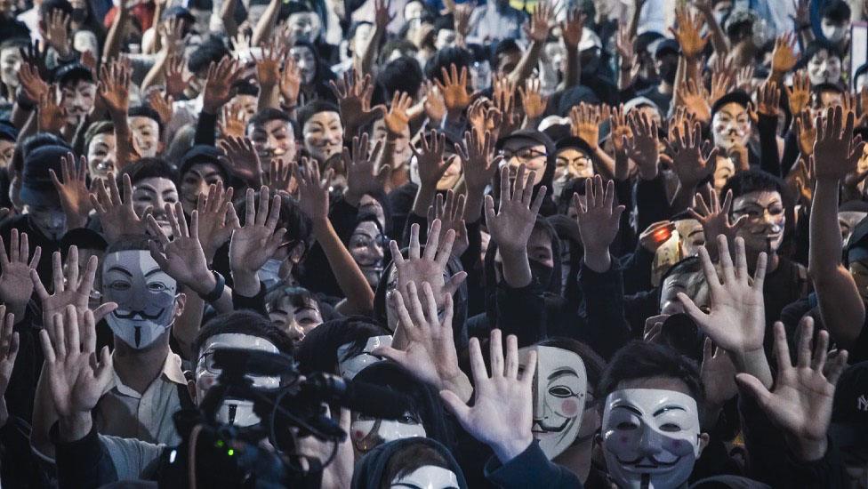 Protesters adopted the motto "Five demands, not one less!" and wore masks in defiance of Carrie Lam plan to invoke colonial-era emergency powers to ban masks