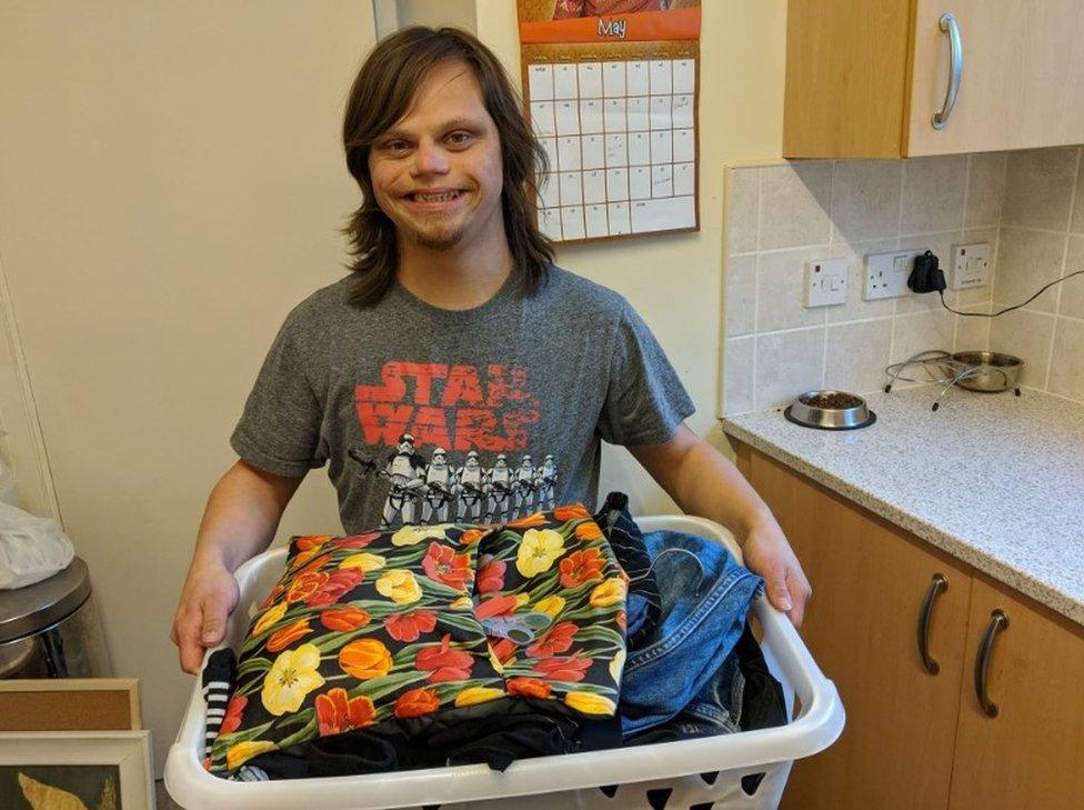 Brent Marriner holding a load of washing he had folded