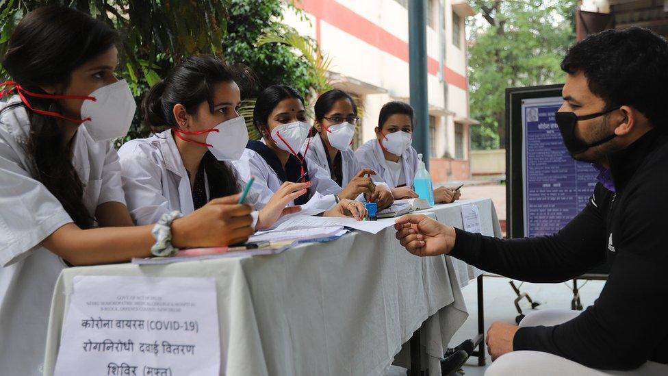 A man speaks to healthcare workers in India