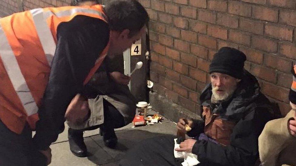 Volunteer helping homeless man