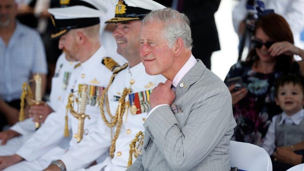 Prince Charles adjusts his tie