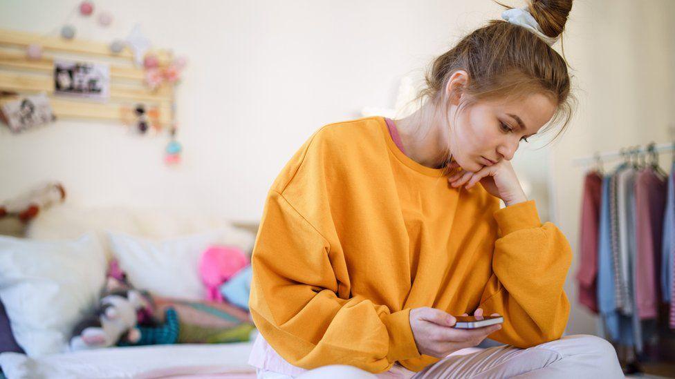 Girl sits on bed