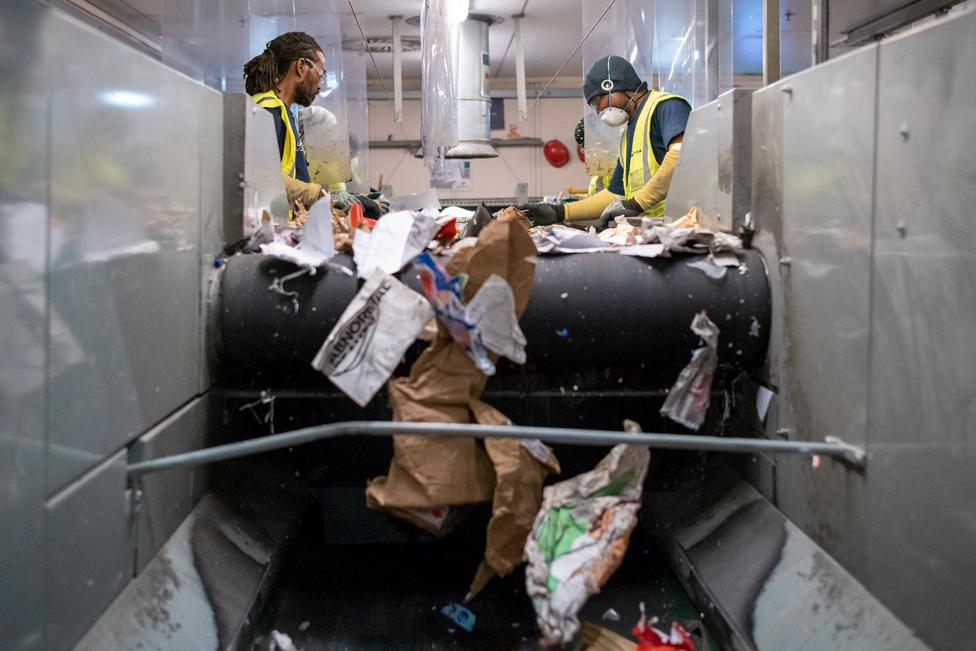 Photo of two people sorting recycling