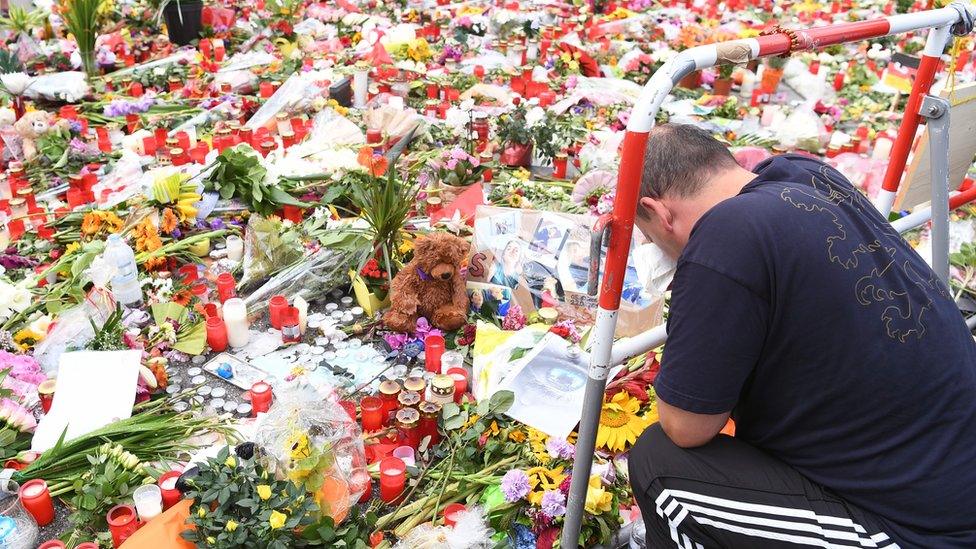 Man prays at memorial