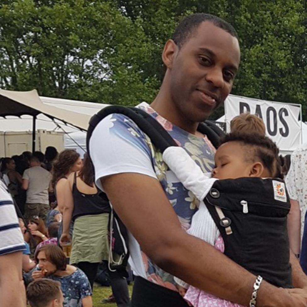 Elliott with his baby daughter in a sling