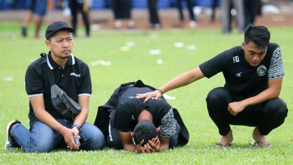 Arema FC players and officials react as they visit Kanjuruhan Stadium