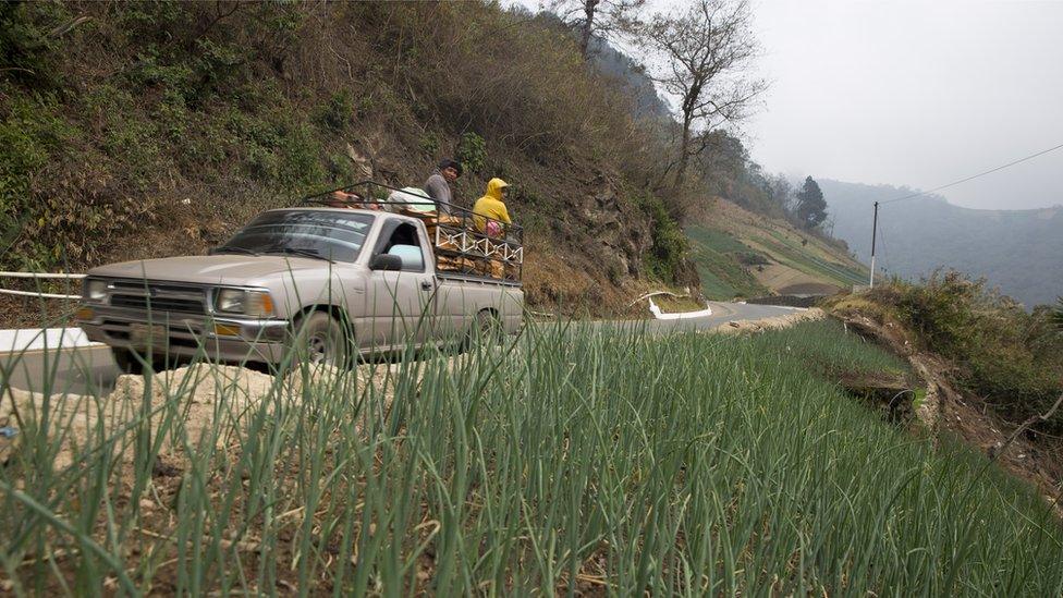 A pick-up truck carries workers in the town of Zunil in Guatemala