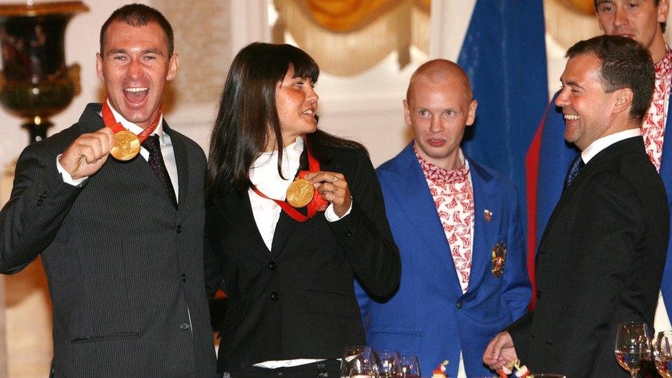 Then Russian President Dmitry Medvedev congratulates 2008 Olympic champions (on left) Maxim Opalev (canoe) and Larisa Ilchenko (open water swimming)