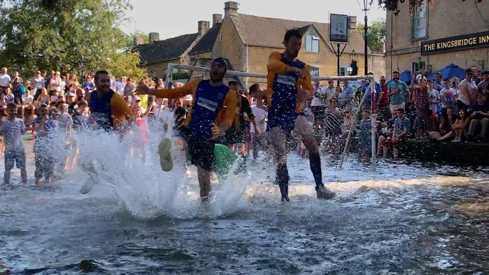 Footballers playing in river