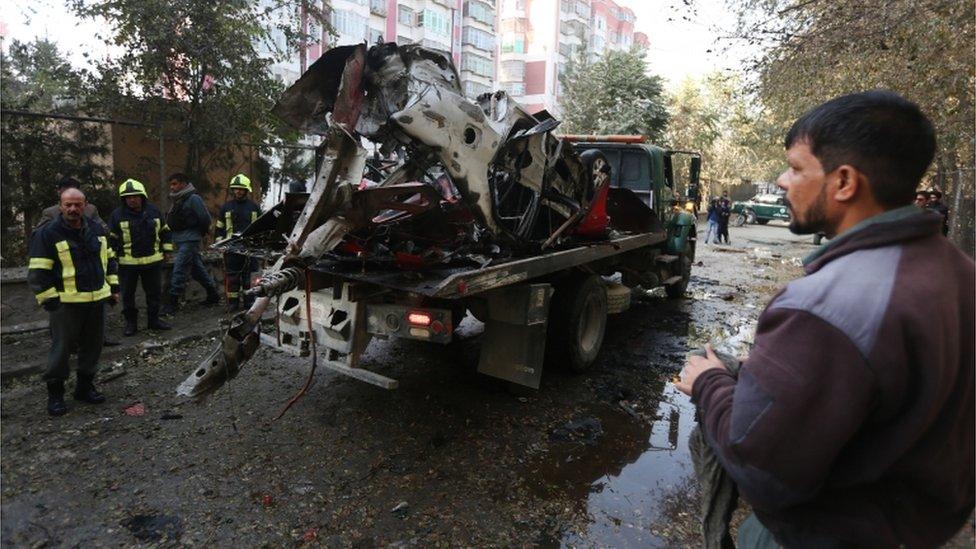 Authorities remove wreckage from the scene of an attack in Kabul