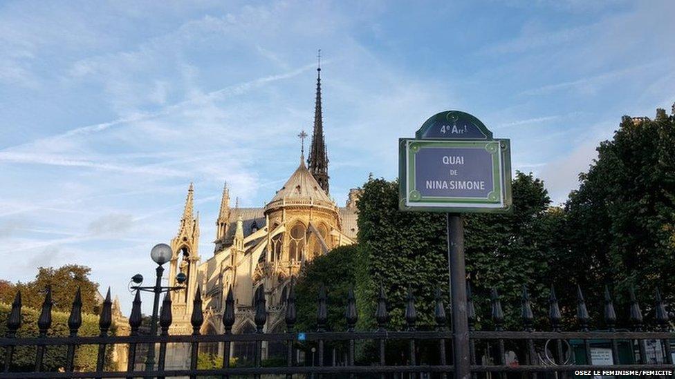 A street sign with Nina Simone's name in front of Notre Dame cathedral