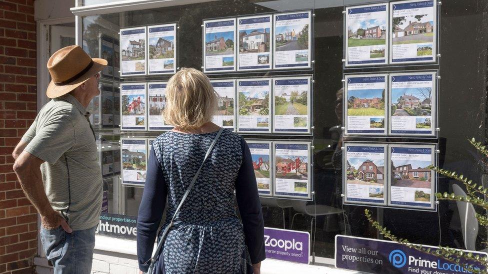 Couple looking at estate agent window