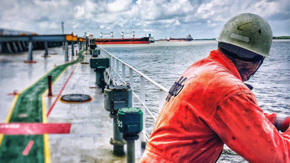 Man on ship staring at other ships.