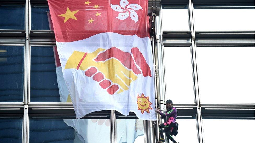 Climber and banner on skyscraper