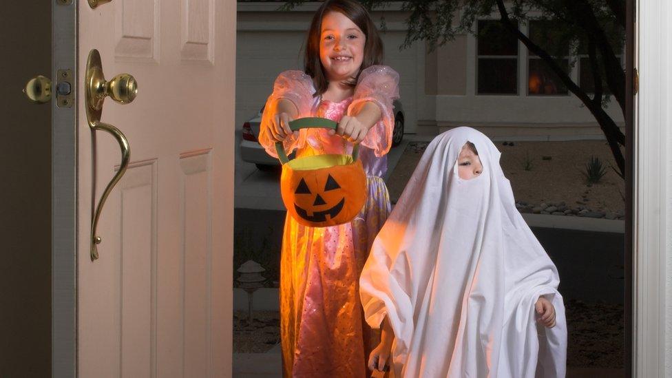 Children trick or treating on Halloween.