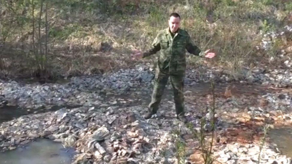 Blogger Anton Alekseev stands on a sodden pile of old Soviet banknotes