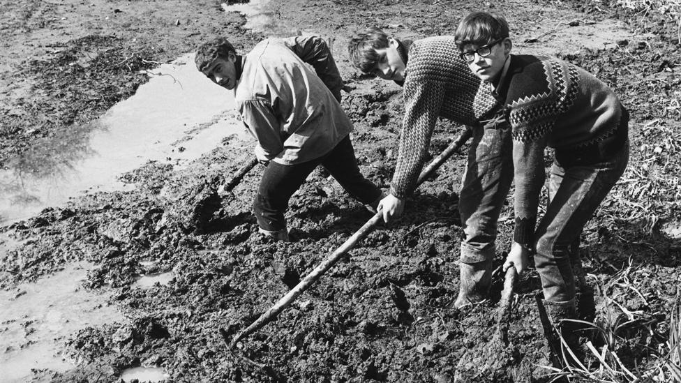 A group of boys from Gordonstoun School helping to clear the moat during restoration work at Michelham Priory near Hailsham, Sussex, 11th April 1967.