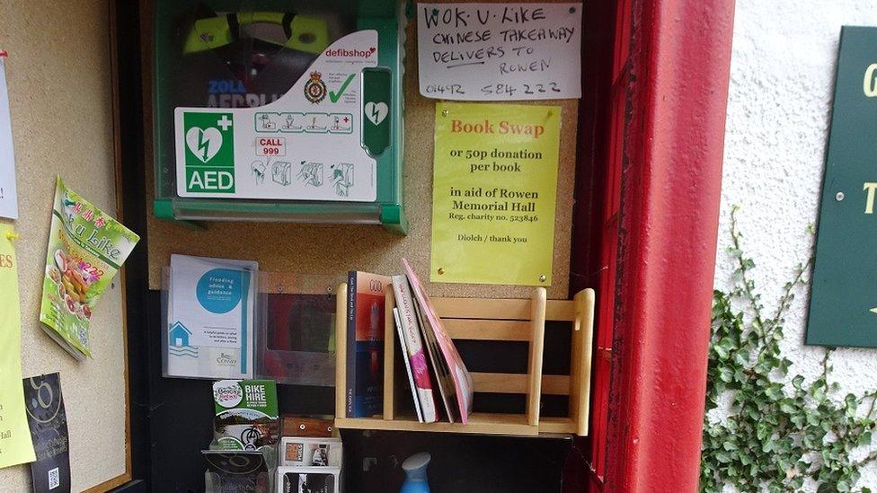 phone box with books and notices