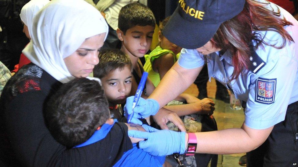 A Czech police officer marks a migrant with a number in Breclav, Czech Republic, 1 September